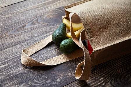 Reusable shopping bag with fresh fruits. Natural eco friendly material. Yellow bananas, green...