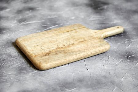 Empty cutting board from pine wood on  stone table, grey background, side viewの写真素材