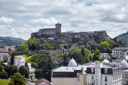 Lourdes, France - June 18, 2018: Chateau Fort of Lourdes and roofs of buildings and hotels. French city is located in the foothills of the Pyrenees mountainsのeditorial素材