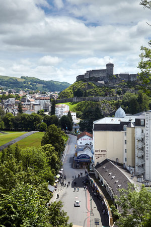 Lourdes, France - June 18, 2018: Chateau Fort of Lourdes and roofs of buildings and hotels. French city is located in the foothills of the Pyrenees mountainsのeditorial素材