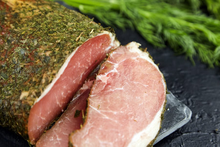 Polendwitz is a jerky tenderloin, dried pork with spices and fresh green dill, slate cutting board...