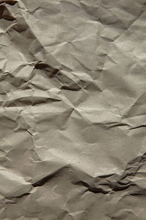 Crumpled craft paper texture background. Natural recycled brown craft paper surface closeupの写真素材