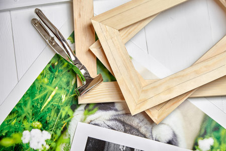 Canvas pliers and photography canvas prints. Tool for wrapping, colorful photos, pile of wooden stretcher bars, top viewの写真素材