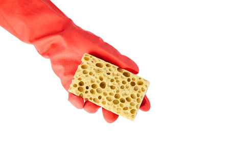 Household sponge from reticulated foam isolated on white background. Hand in red rubber glove...