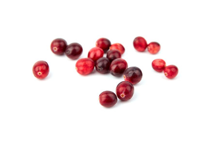 cranberries isolated on white background. Heap of fresh red berries. Scattered autumn large...