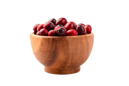 Cranberries in wooden bowl isolated on white background. Fresh red ripe cranberry autumn berriesの写真素材