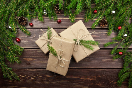 Christmas and New Year gift boxes with fir tree branches, cones and berries on wooden background,...