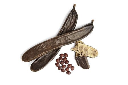 Carob beans with seeds isolated on white background. Healthy organic sweet carob pods. Top view.の写真素材
