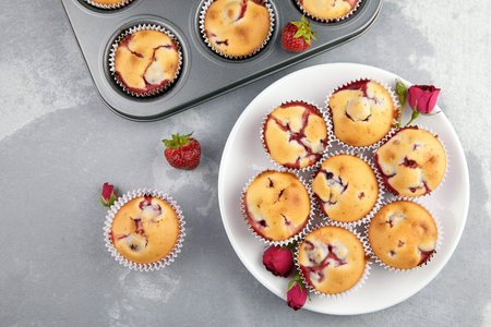 Strawberry muffin dessert with fresh ripe strawberry on gray background, flat lay, homemade summer...