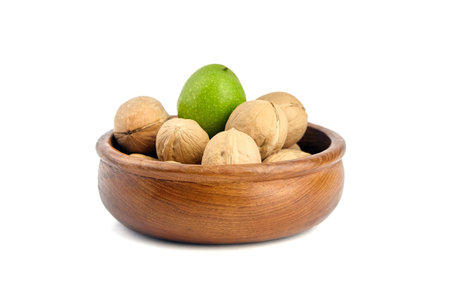 Wooden bowl with walnuts isolated on white background