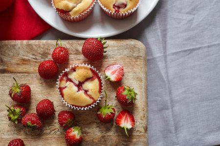 Strawberry muffins with fresh strawberries on wooden board background, top view, copy spaceの写真素材