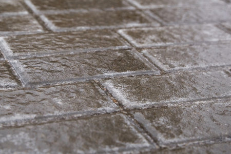 Ice crusted ground, paving slabs surface covered ice, slippery street, winter weather. Icy sidewayの写真素材