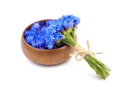 Blue cornflowers bouquet with wooden bowl isolated on white backgroundの写真素材