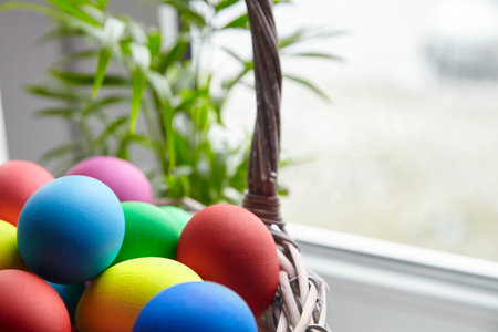 Easter Sunday or Easter Day (Pascha). Basket with colorful Easter Eggs on blurred background....