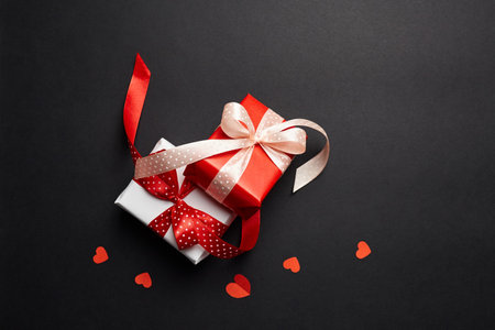 Valentines day gift boxes with red hearts on black paper backgroundの写真素材