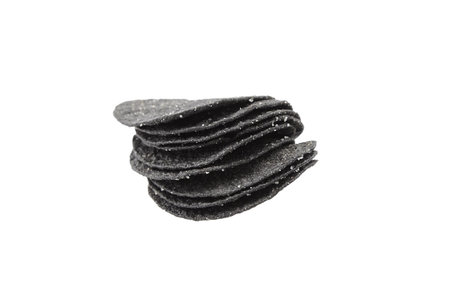 Black potato chips isolated on white background. Beer snack, stacked potato chips
