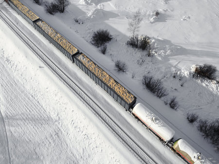 Aerial view of cargo train tank wagons, a double-track railway. Winter rail road with white snow,...