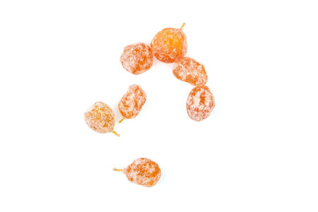 Sugar coated kumquats isolated on white background, top view. Candied fruits, scattered heap of dried kumquats.の写真素材
