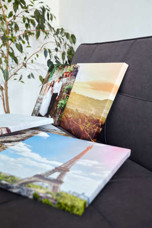 Canvas prints. Photo printed on canvas with gallery wrapping on stretcher bar. Different photos stacked on sofa. Colorful photographyの写真素材