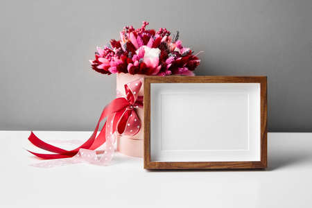 Photo or artwork frame mockup and dried flowers on gray wall backgroundの写真素材