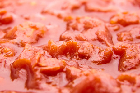 Chopped tomatoes in tomato juice red food background closeupの写真素材