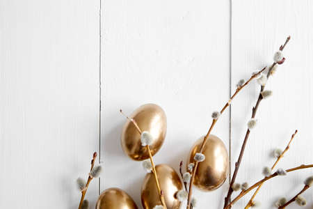 Easter eggs with pussy willow branches on white wooden table happy holiday background top viewの写真素材