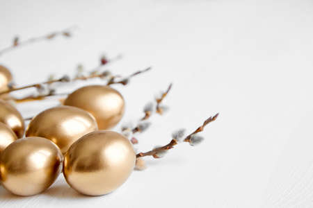Easter eggs with pussy willow branches on white wooden table happy holiday backgroundの写真素材