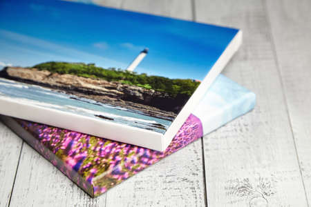Stretched canvas photo prints stacked on white wooden backgroundの写真素材