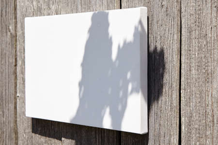 White stretched canvas mockup with flower shadow on wooden backgroundの写真素材