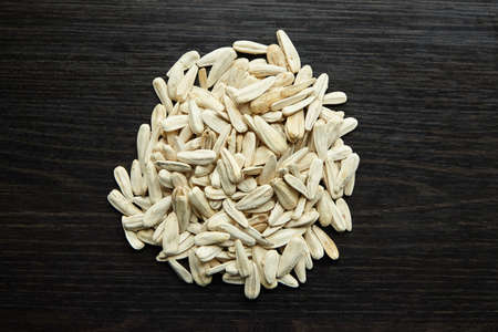 White sunflower seeds heap over wooden background, top viewの写真素材