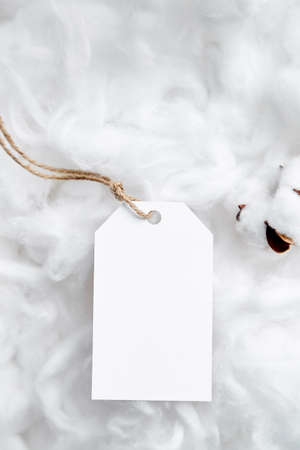 Label tag mockup and white cotton flowers on soft backgroundの写真素材
