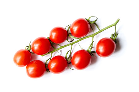 Cherry tomatoes cluster isolated on white background. fresh vegetable. Red cherry tomatoes on stem, top viewの写真素材