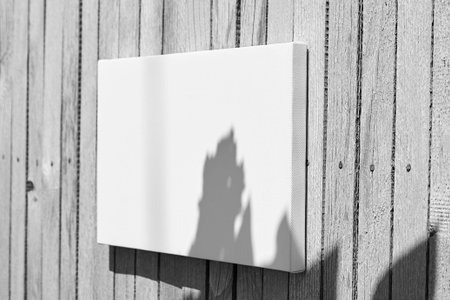 White stretched canvas mockup with flower shadow on wooden background