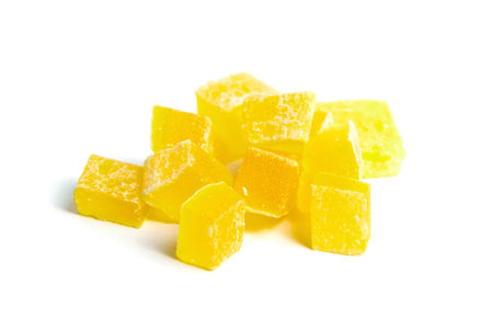 Dehydrated mango dices isolated on white background. Dried mango cubes. Heap of candied diced fruits closeupの写真素材