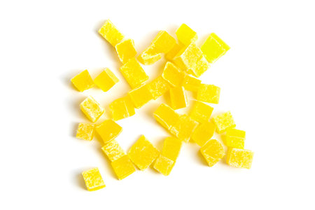 Dried mango cubes isolated on white background, top view. Diced mango closeup. Heap of sweetened fruitsの写真素材