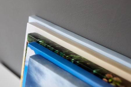 Canvas prints stacked on white surface on gray wall background. Photo printed on canvas. Stretched...