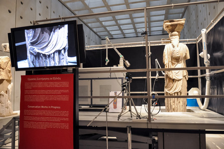 ATHENS, GREECE - JANUARY 28, 2011: Restoration and conservation work on the Caryatids at the New Acropolis Museum. Laser equipment on platform to remove surface contamination.のeditorial素材