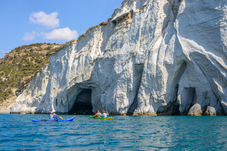 MELOS, GREECE - SEPTEMBER 4, 2012: People with kayaks exploring the caves next to Gerontas beach off the south coast of Melos island.のeditorial素材