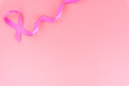 Pink ribbon breast cancer on pink background with copy space for text. Flat lay, top view.の写真素材
