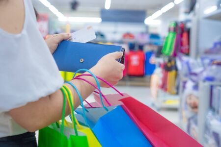 Close up woman hand holding purse, shopping bag and credit card in the shopping mall. Shopping concept.の写真素材