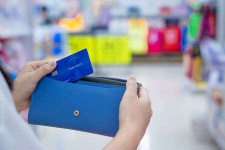 Close up woman hand holding purse, shopping bag and credit card in the shopping mall. Shopping concept.の写真素材
