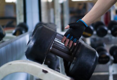 Close up hand taking heavy rusty dumbbell to exercise for strength training. sport, fitness, health, lifestyle and people conceptの写真素材