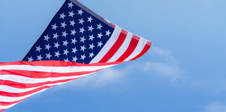 US American flag on blue sky background. For USA Memorial day, Veterans day, Labor day, or 4th of July celebration. Top view, copy space for text.の写真素材