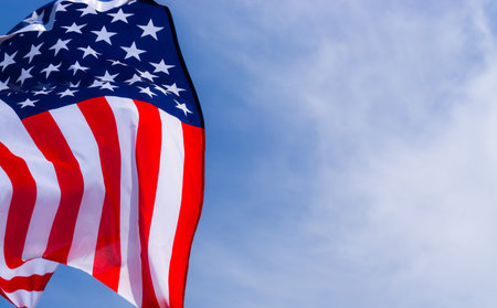 US American flag on blue sky background. For USA Memorial day, Veterans day, Labor day, or 4th of...