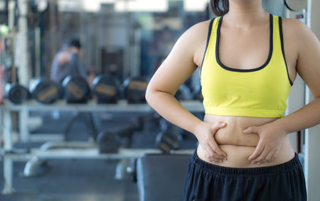 Close up woman holding excessive fat belly. Woman overweight abdomen. Woman diet lifestyle concept...