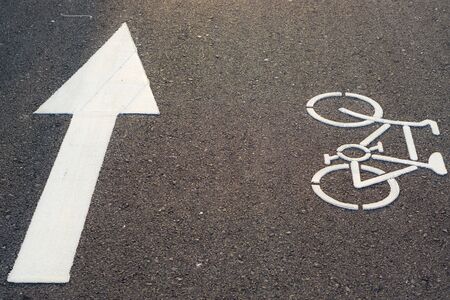 Bicycle lane marking or bike road sign with an arrow on the street in the public park.の写真素材
