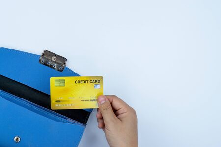 Woman hand taking out the credit card from blue purse for payment on the white background. Finance and money concept, top view, copy space for text.の写真素材