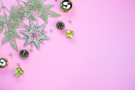 Christmas holidays composition, top view of gold Christmas decorations on pink background with copy space for text. Flat lay, winter, postcard template, new year concept.の写真素材