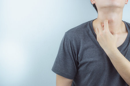 Close up man scratching his itchy neck with allergy rash by hand on white background. Healthcare,...