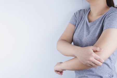 Closeup woman suffering from arm and elbow pain. Health care and medical concept.の写真素材
